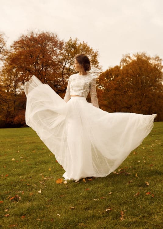 bride in field dancing with wedding dress